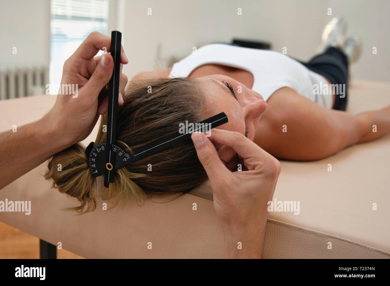Goniometry cervicale, fisioterapista e giovane femmina. Foto Stock