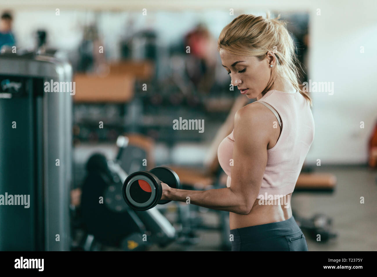 Donna esercizio con pesi nella palestra. Tonica immagine. Foto Stock