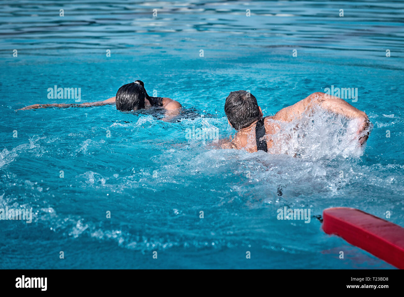Piscina bagnino verso la donna di annegamento. Foto Stock