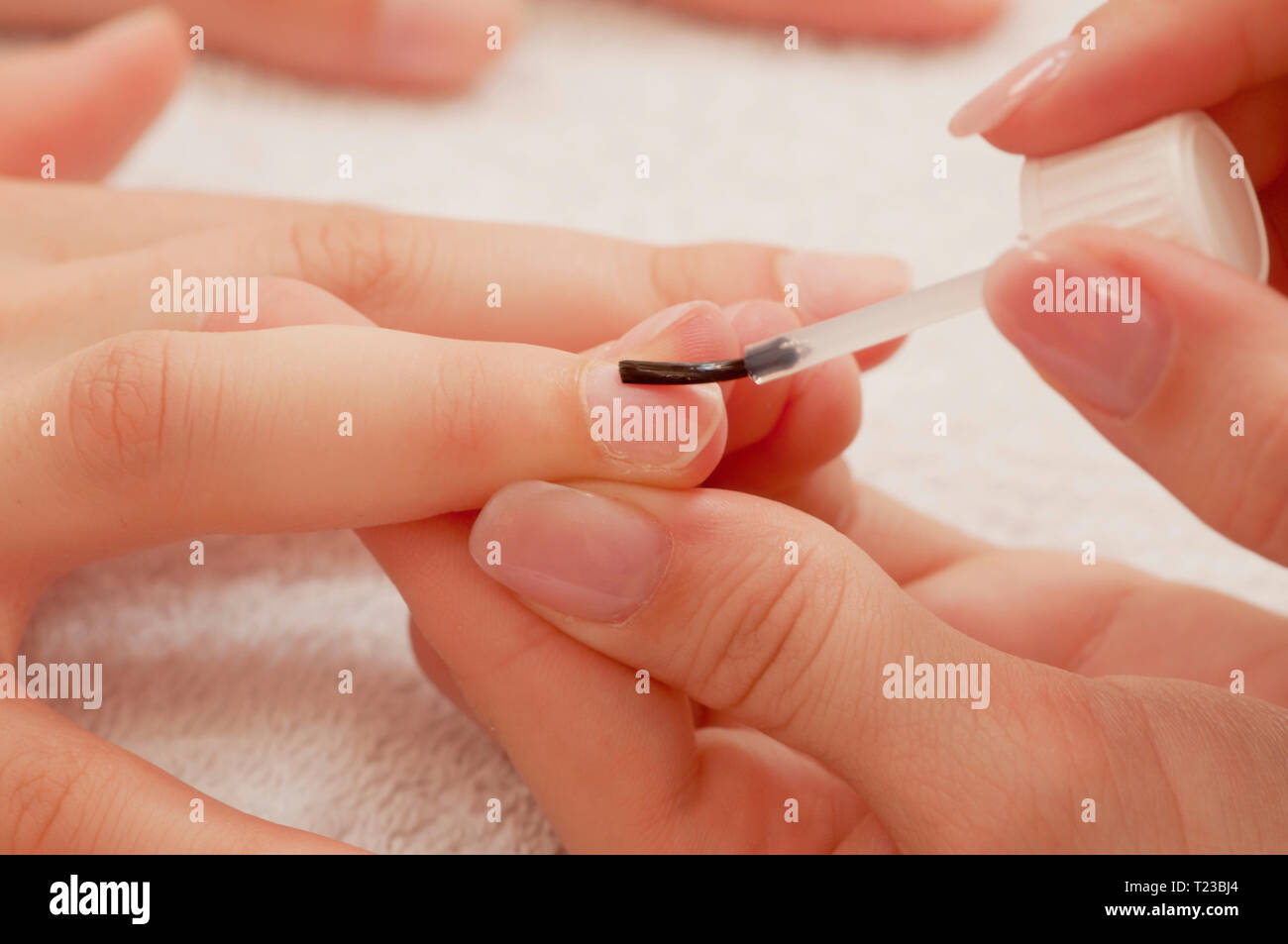 L'applicazione di rivestimento di base di un unghia alla manicure. Foto Stock