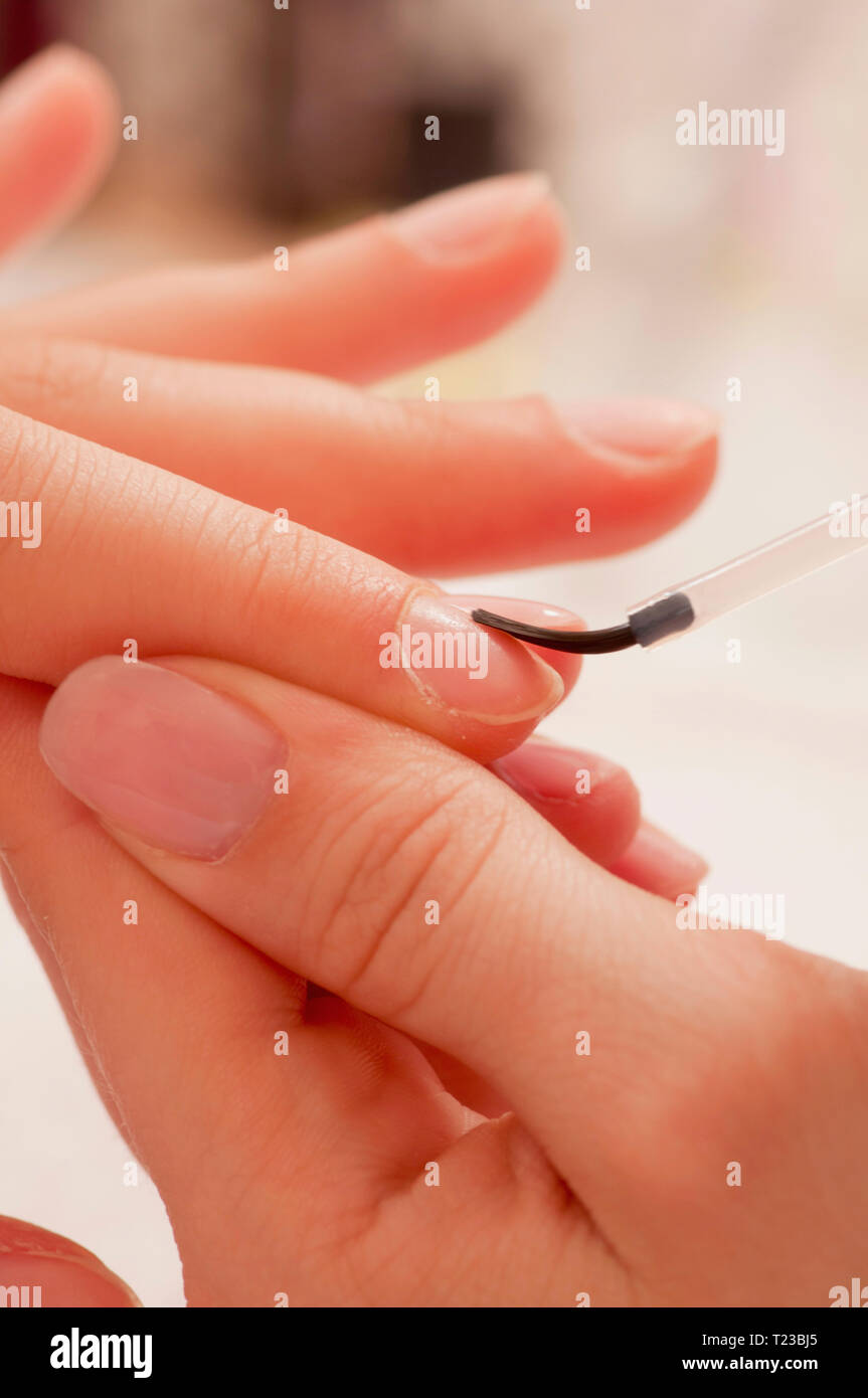 L'applicazione di rivestimento di base di un unghia alla manicure. Foto Stock