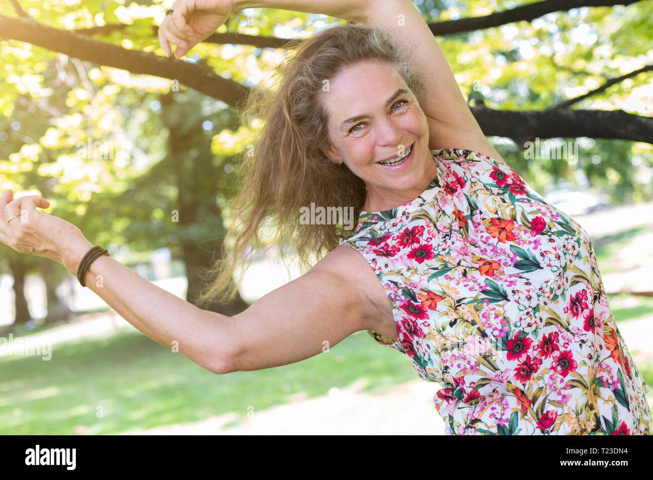 Ritratto di felice coppia donna che indossa top con disegno floreale dancing in un parco Foto Stock