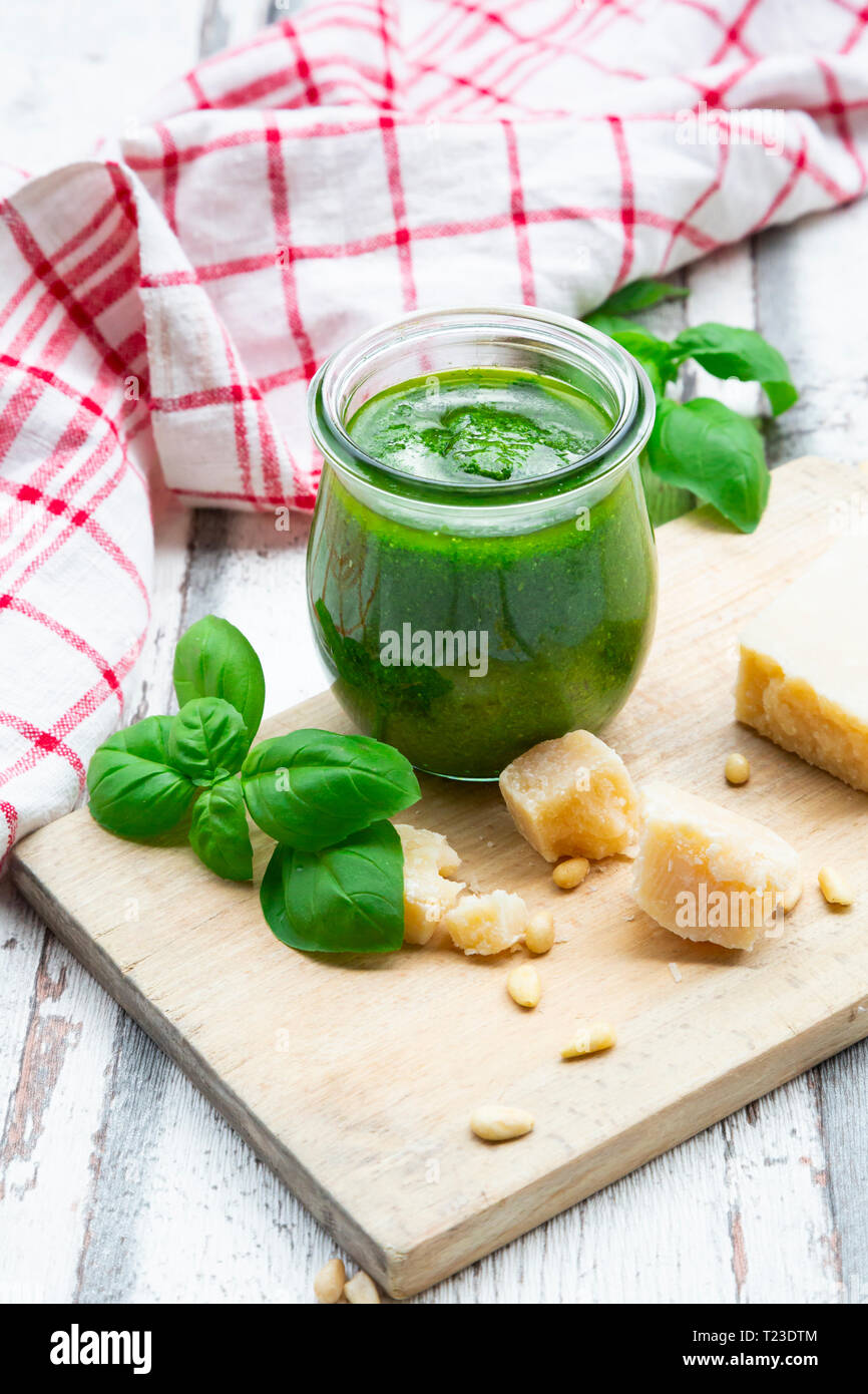 Di vetro in casa pesto genovese, ingredienti e asciugamano da cucina Foto Stock