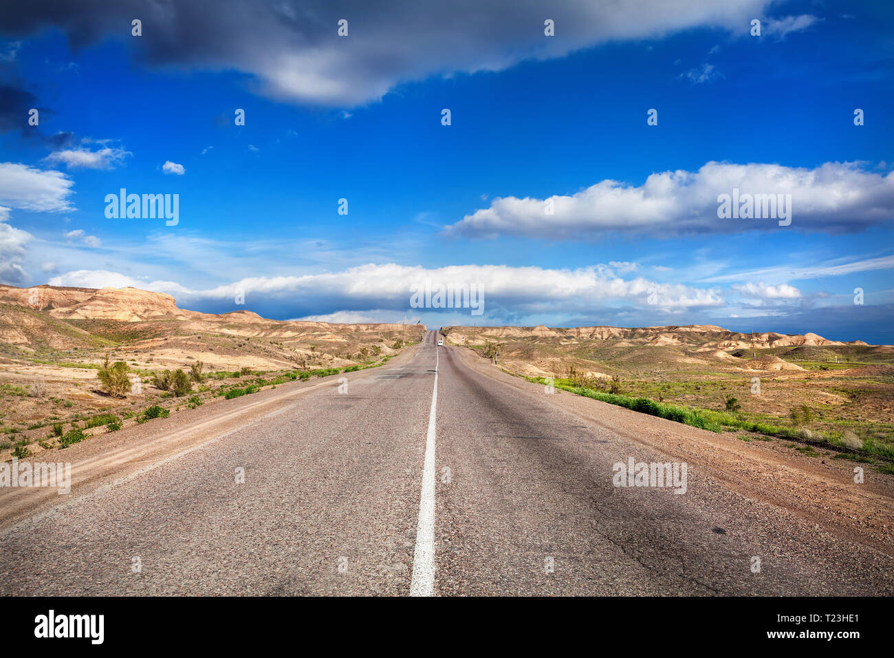 Autostrada strada nel deserto e nuvoloso cielo blu Foto Stock