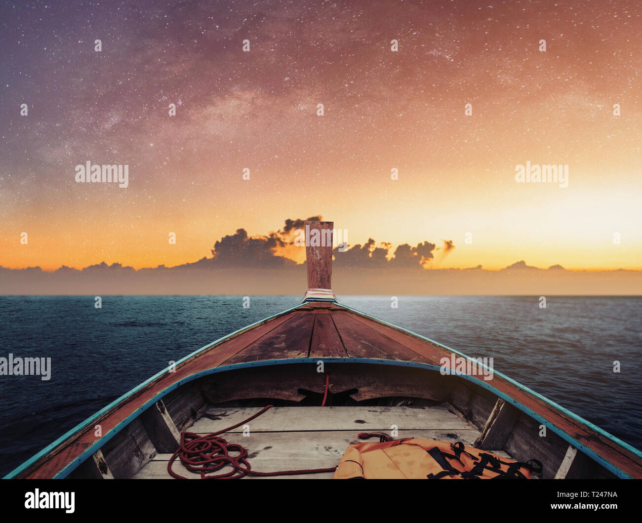 Il viaggio in barca di notte sull'oceano, in alba con cielo stellato e luce solare su orizzonte Foto Stock