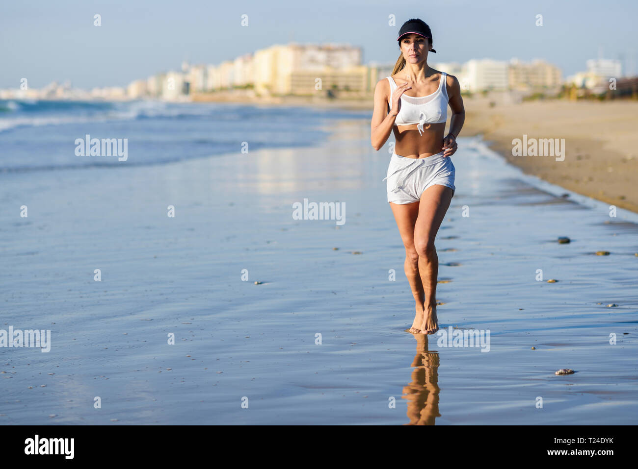 Donna sportive in esecuzione sulla spiaggia Foto Stock