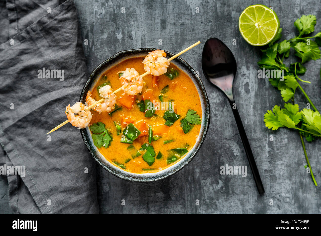Ciotola di patata dolce zuppa di gamberetti, scaglie di noce di cocco e di coriandolo fresco Foto Stock