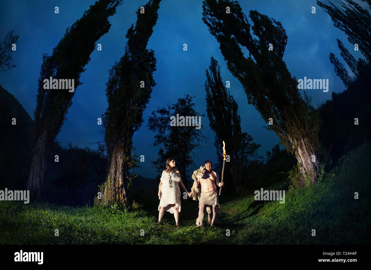 Primitivo persone vestite di animale con torcia luce nel buio del bosco Foto Stock