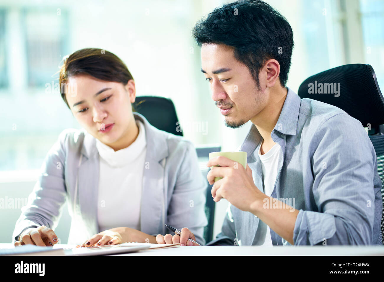 Asian imprenditore e imprenditrice lavorando insieme in ufficio a discutere di business plan. Foto Stock