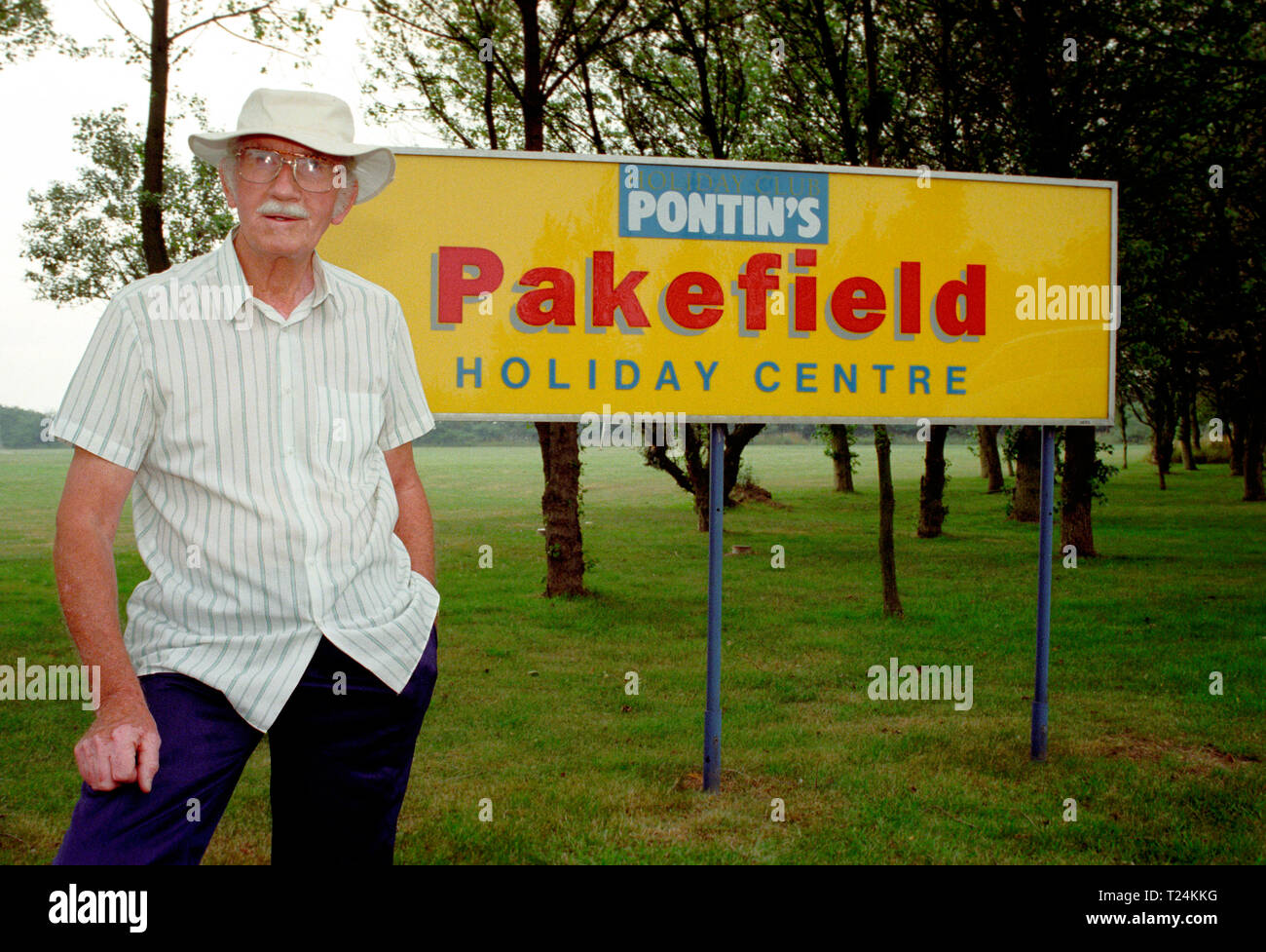 Uomo anziano in piedi da una Pontin's Holiday camp segno, Pakefield, Lowestoft, Inghilterra Foto Stock