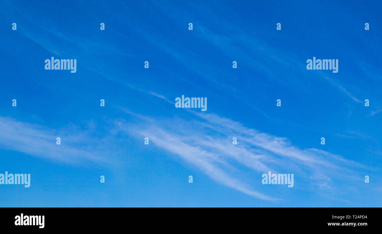 La luce blu del cielo lo sfondo con la striatura di nuvole bianche Foto Stock