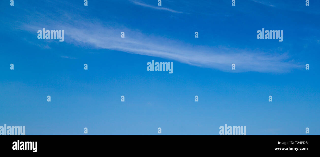 La luce blu del cielo lo sfondo con un po' di striature di nuvole bianche Foto Stock