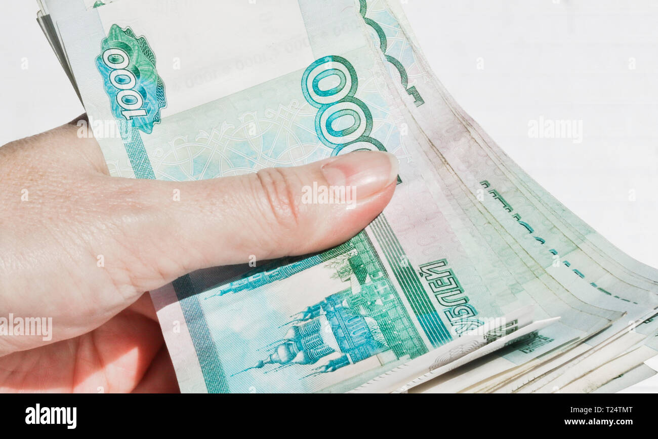 Un pack di 1000 ruble banconote compressa in mano Foto Stock