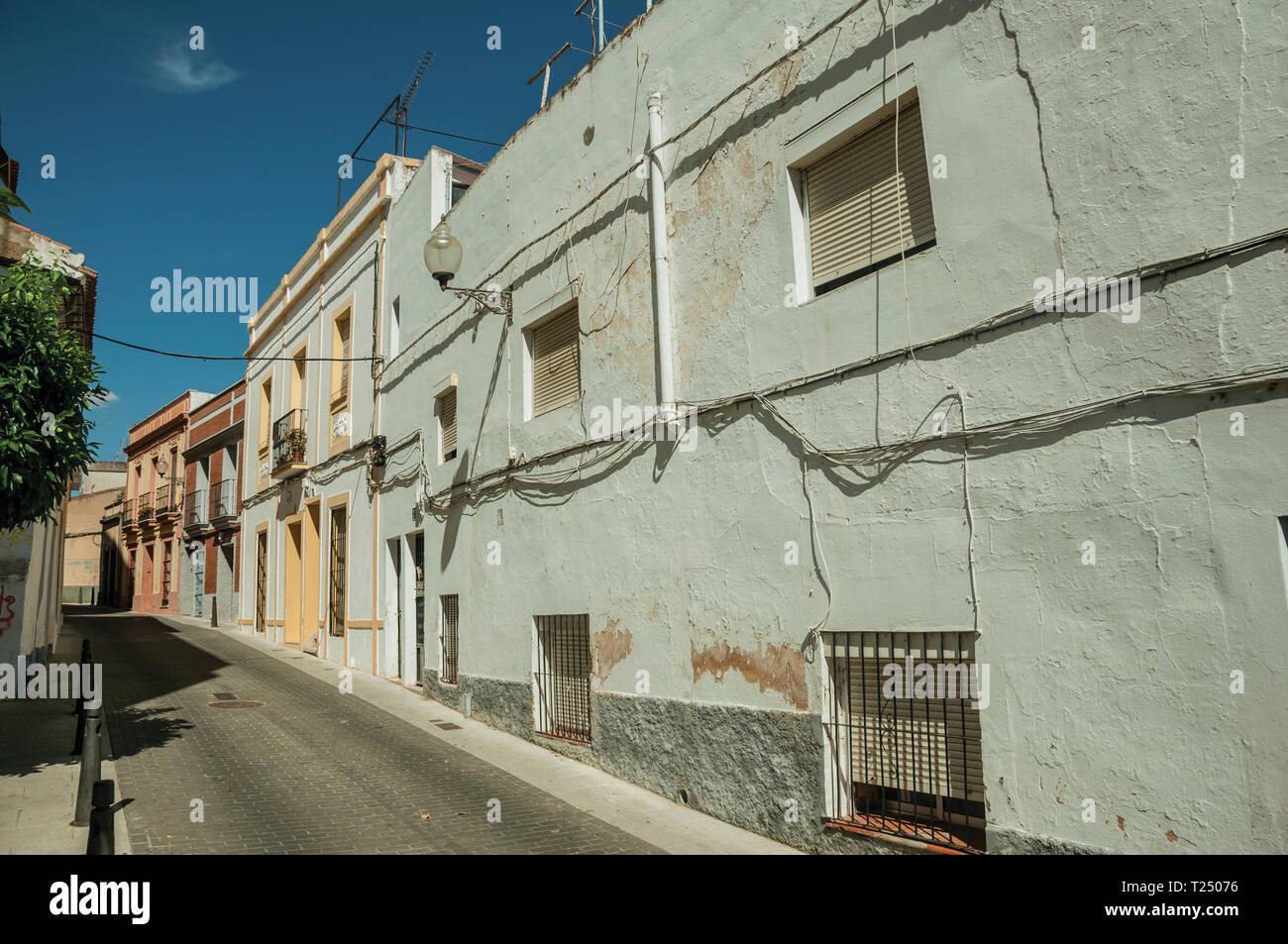 Facciata di edifici con finestre su strada tranquilla in una giornata di sole a Merida. La città conserva molti edifici della Roma antica in Spagna. Foto Stock