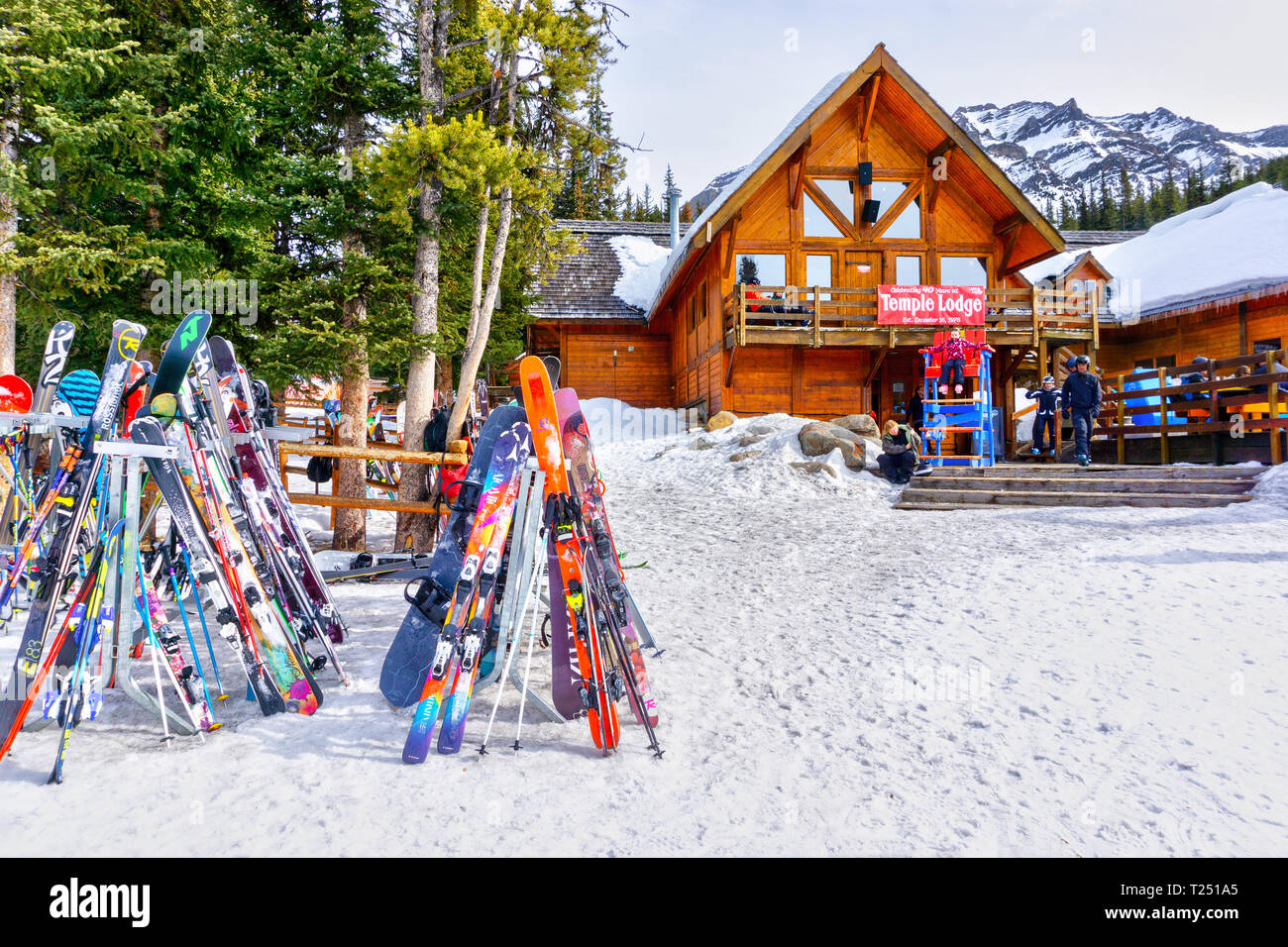Il Lago Louise, Canada - 23 MAR 2019: sci colorati e linea snowboads la cremagliera al di fuori del vecchio e rustico Tempio Lodge at Lake Louise in attacco posteriore Foto Stock