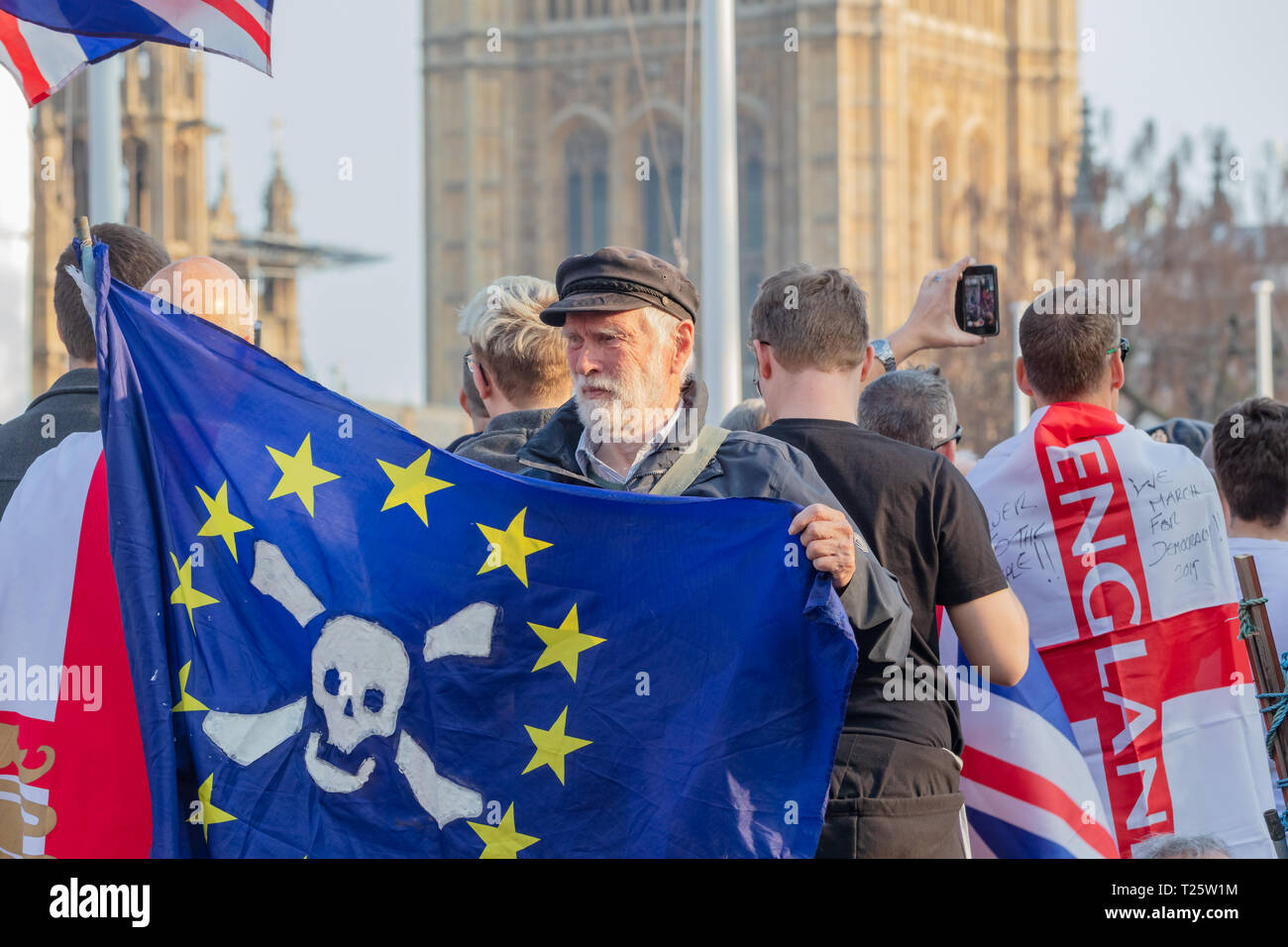 Westminster, Londra, Regno Unito; 29 marzo 2019; Pro-Brexit Demonstrator detiene il Flag durante il mese di marzo a lasciare il Rally in piazza del Parlamento. Il Parlamento dietro Foto Stock