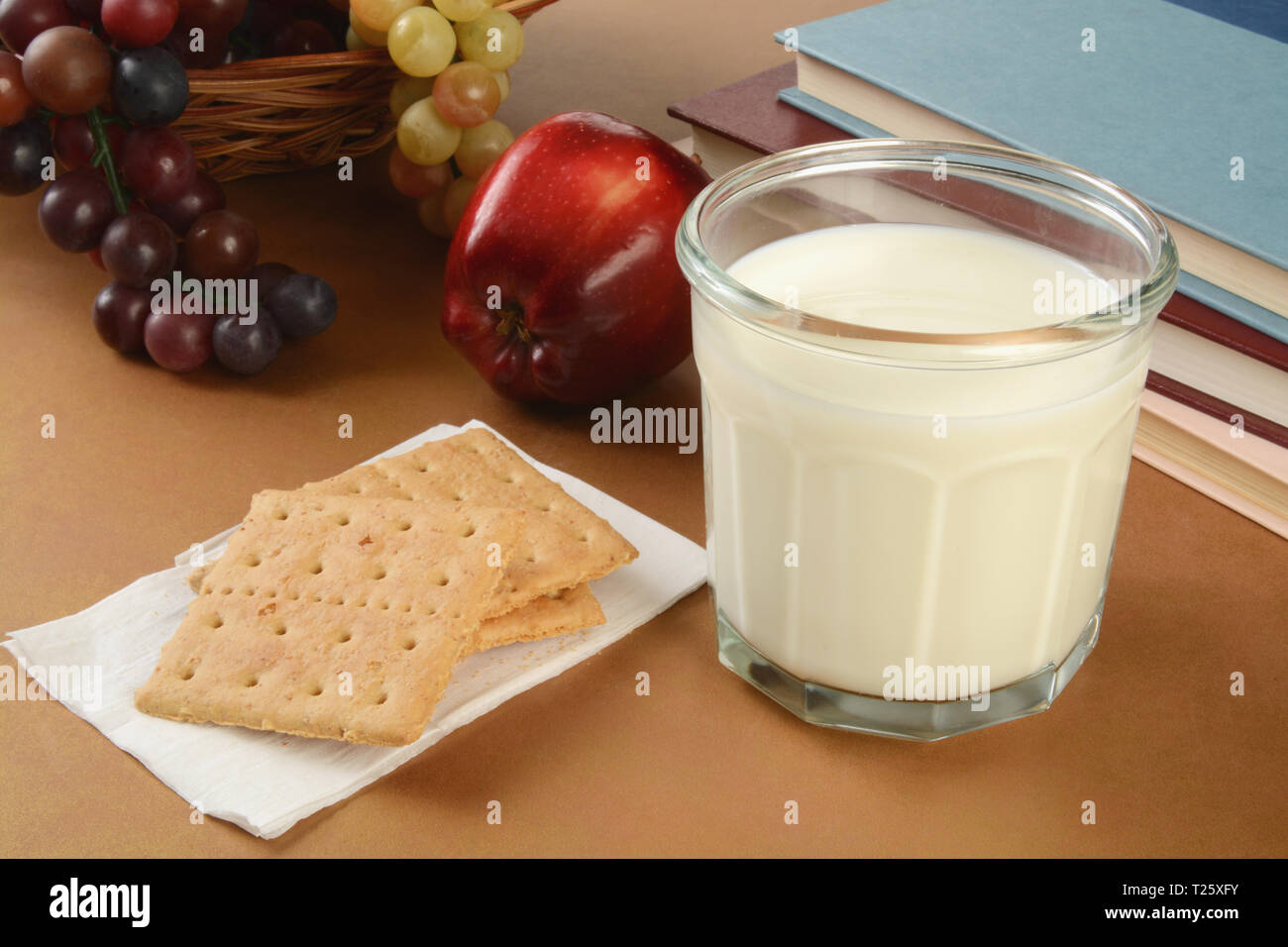 Graham cracker e un bicchiere di latte con un Apple come un sano dopo la scuola snack Foto Stock