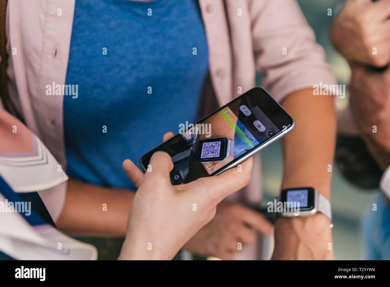 Dipendente della compagnia aerea di scansione dei codici QR di passeggeri con smartwatch in aeroporto Foto Stock