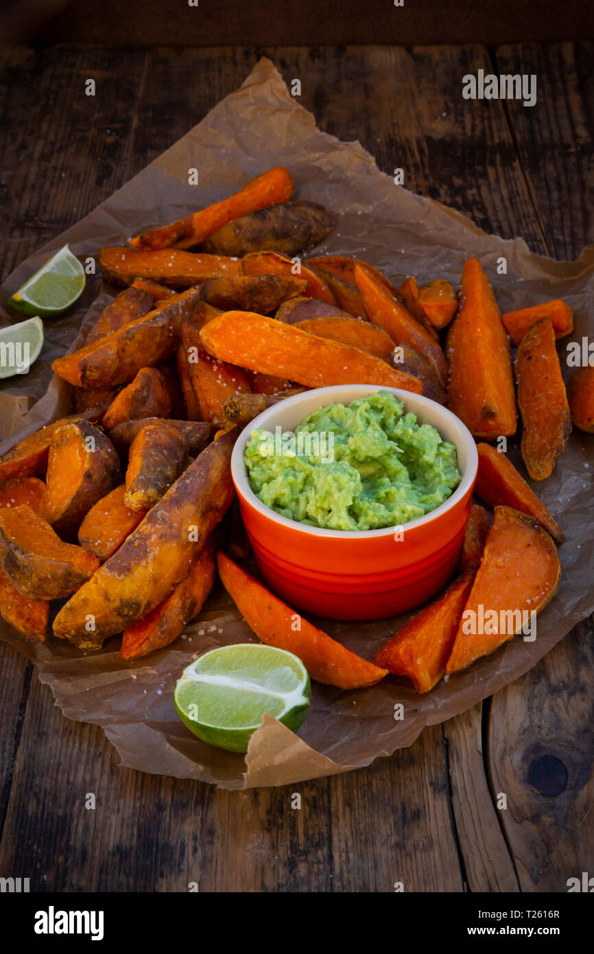 La patata dolce cunei con avocado dip Foto Stock