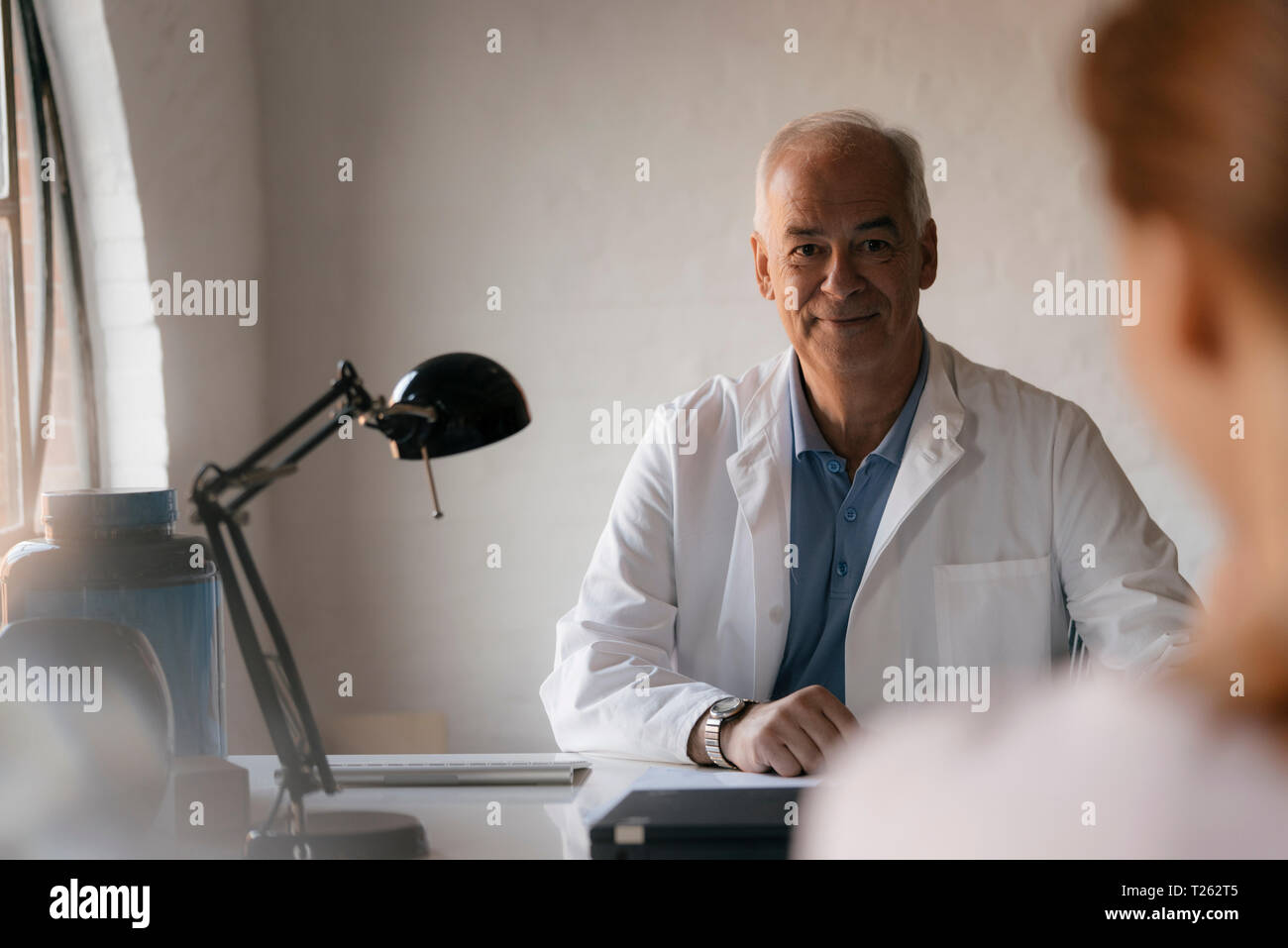 Senior medico guardando al paziente di sesso femminile nella pratica medica Foto Stock