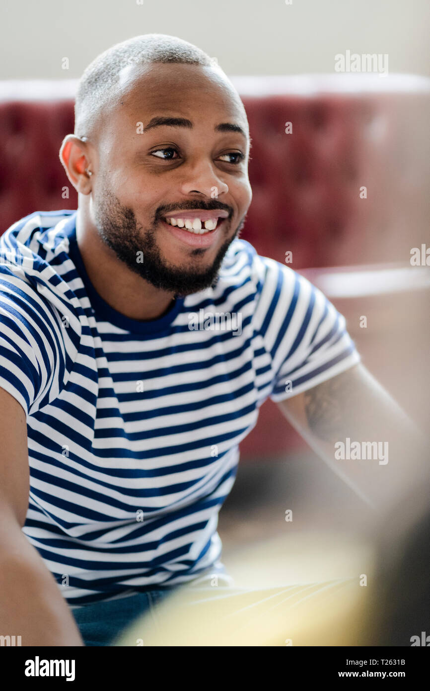 Ritratto di giovane sorridente uomo a strisce che indossa la t-shirt Foto Stock