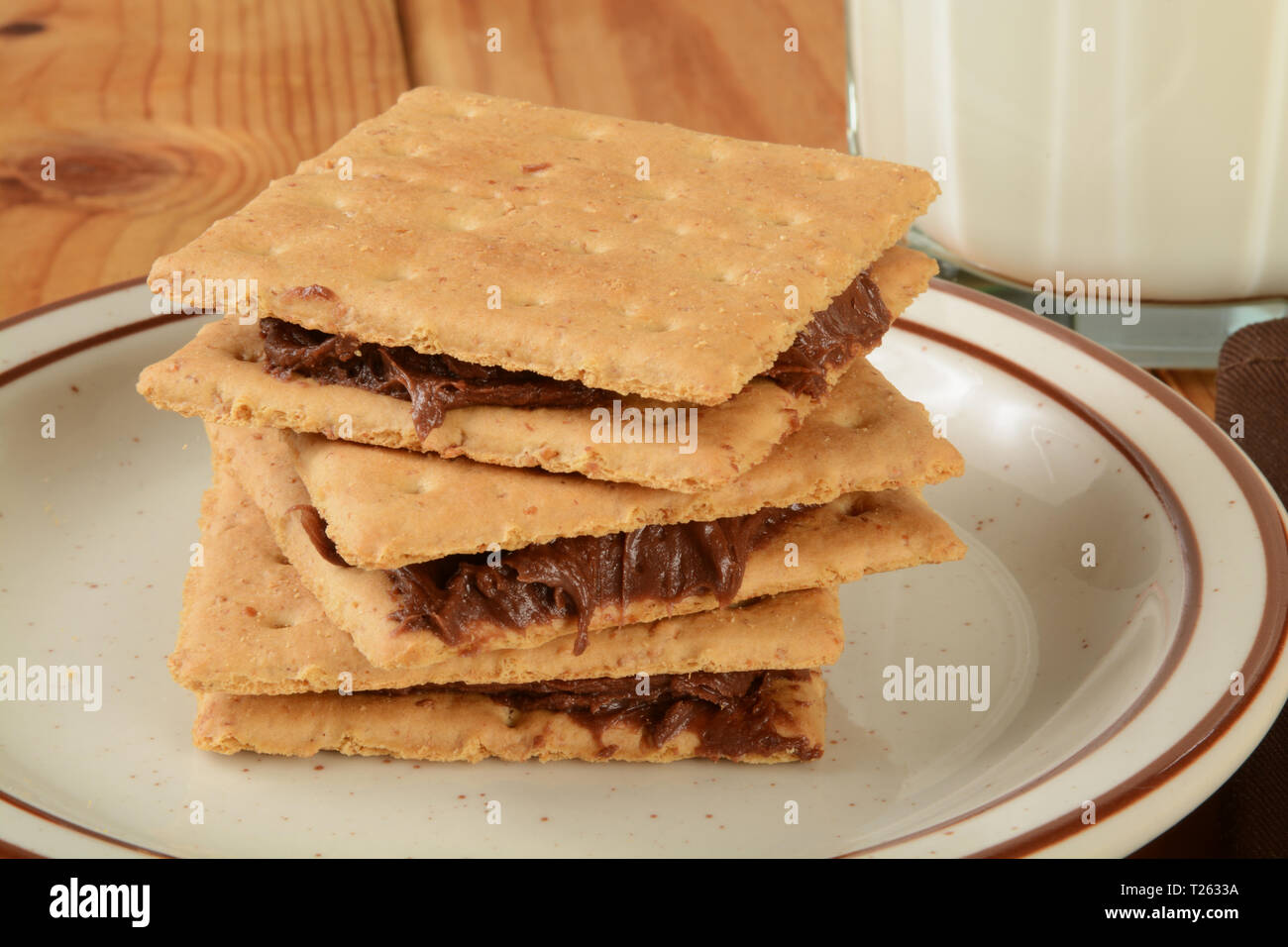 Graham crackers con glassa di cioccolato e un bicchiere di latte Foto Stock