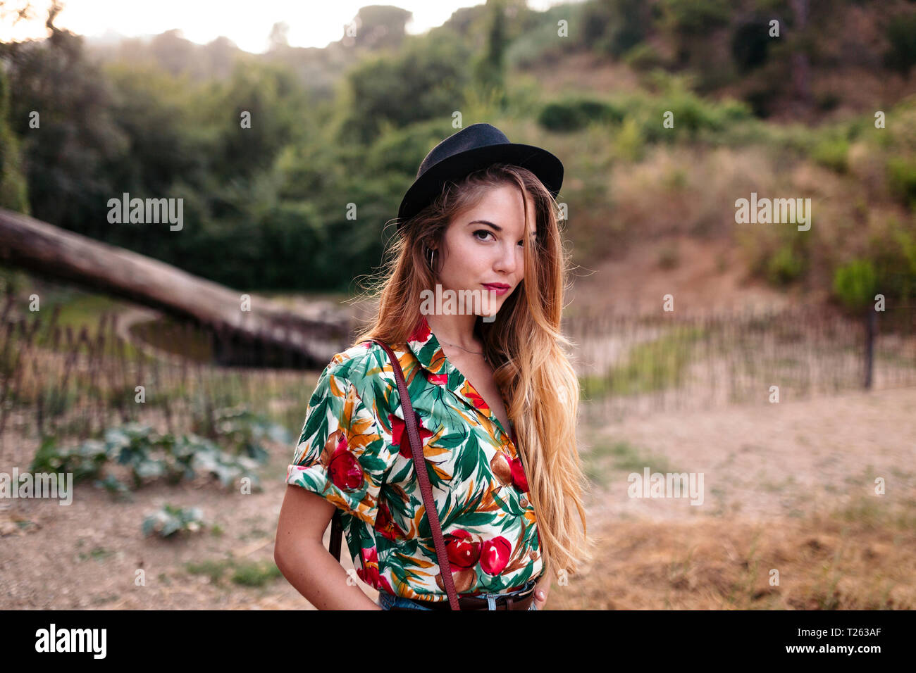 Bella giovane donna con capelli lunghi biondi in un parco Foto Stock