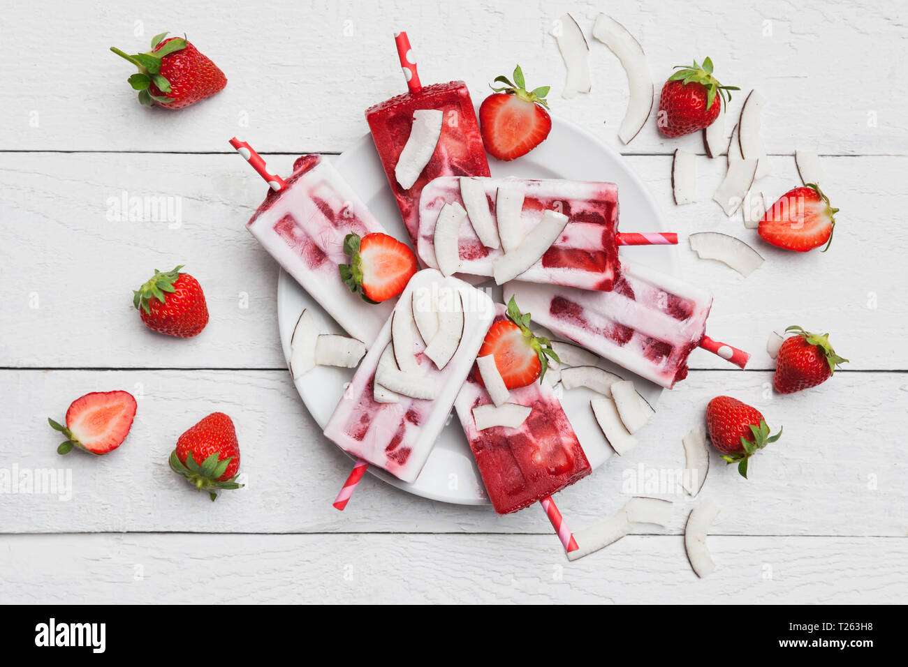 In casa di cocco fragola ghiaccioli con fragole fresche e fette di noce di cocco sulla piastra Foto Stock