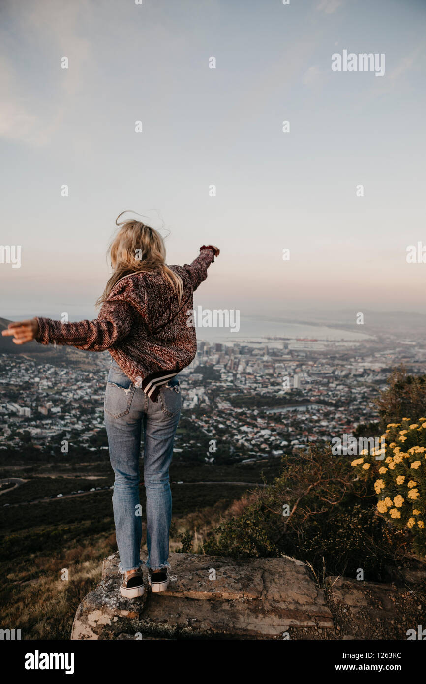 Sud Africa, Cape Town, Kloof Nek, donna felice godendo la vista al tramonto Foto Stock