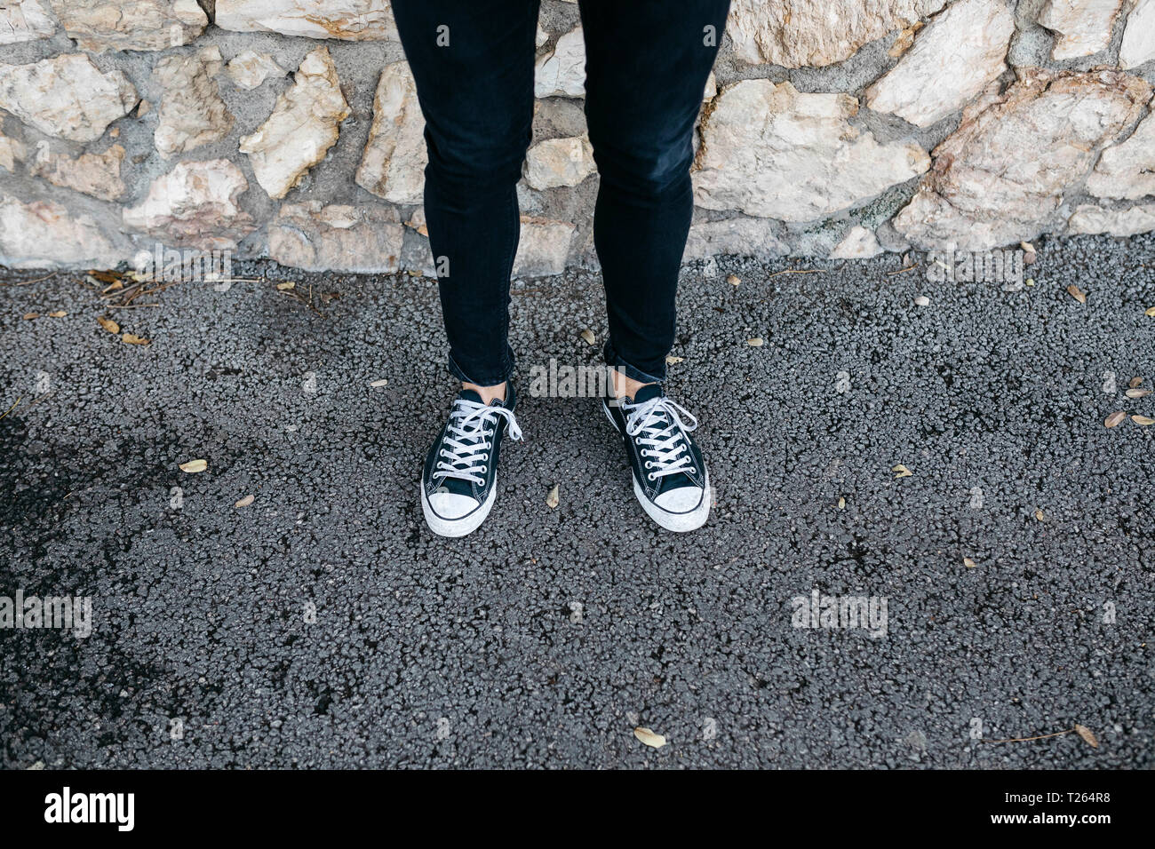 Le gambe del giovane uomo che indossa abiti casual in piedi Foto Stock