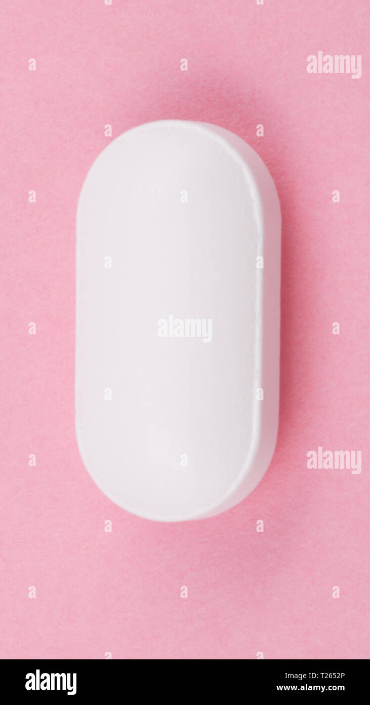 Pillola bianco su sfondo rosa Foto Stock