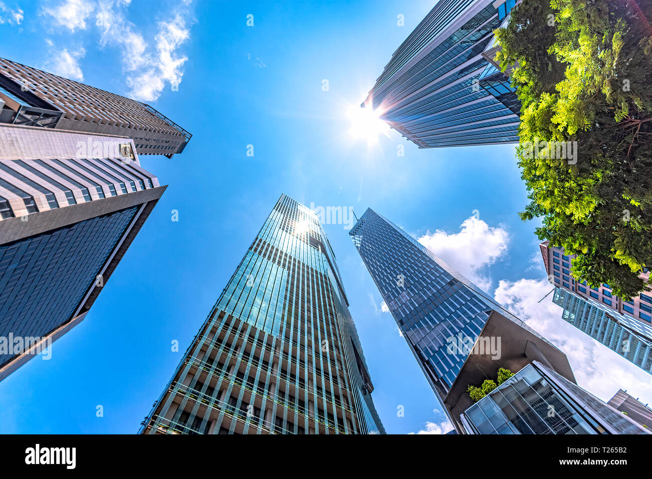 Singapore, edifici alti, basso angolo di vista contro il sole Foto Stock