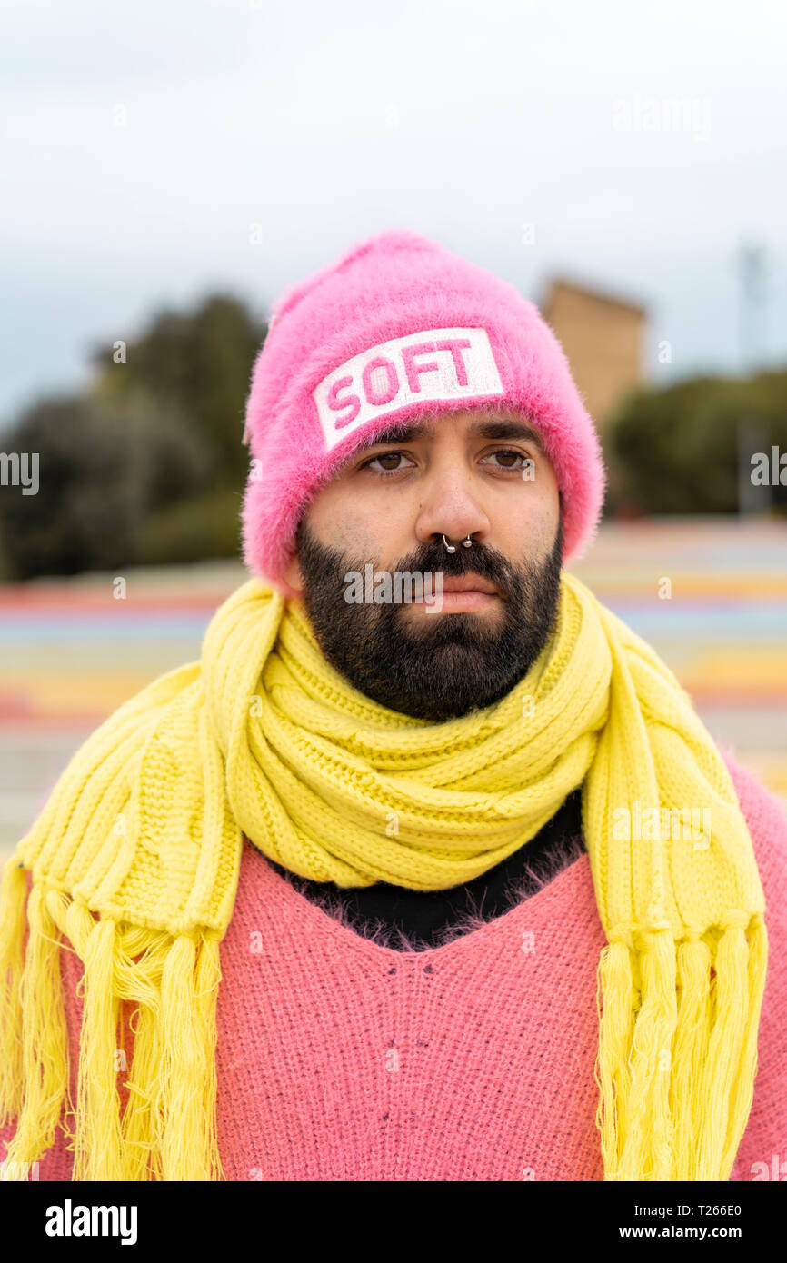Ritratto di barbuto gay con piercing per il naso indossando cappello rosa con la parola 'soft' Foto Stock