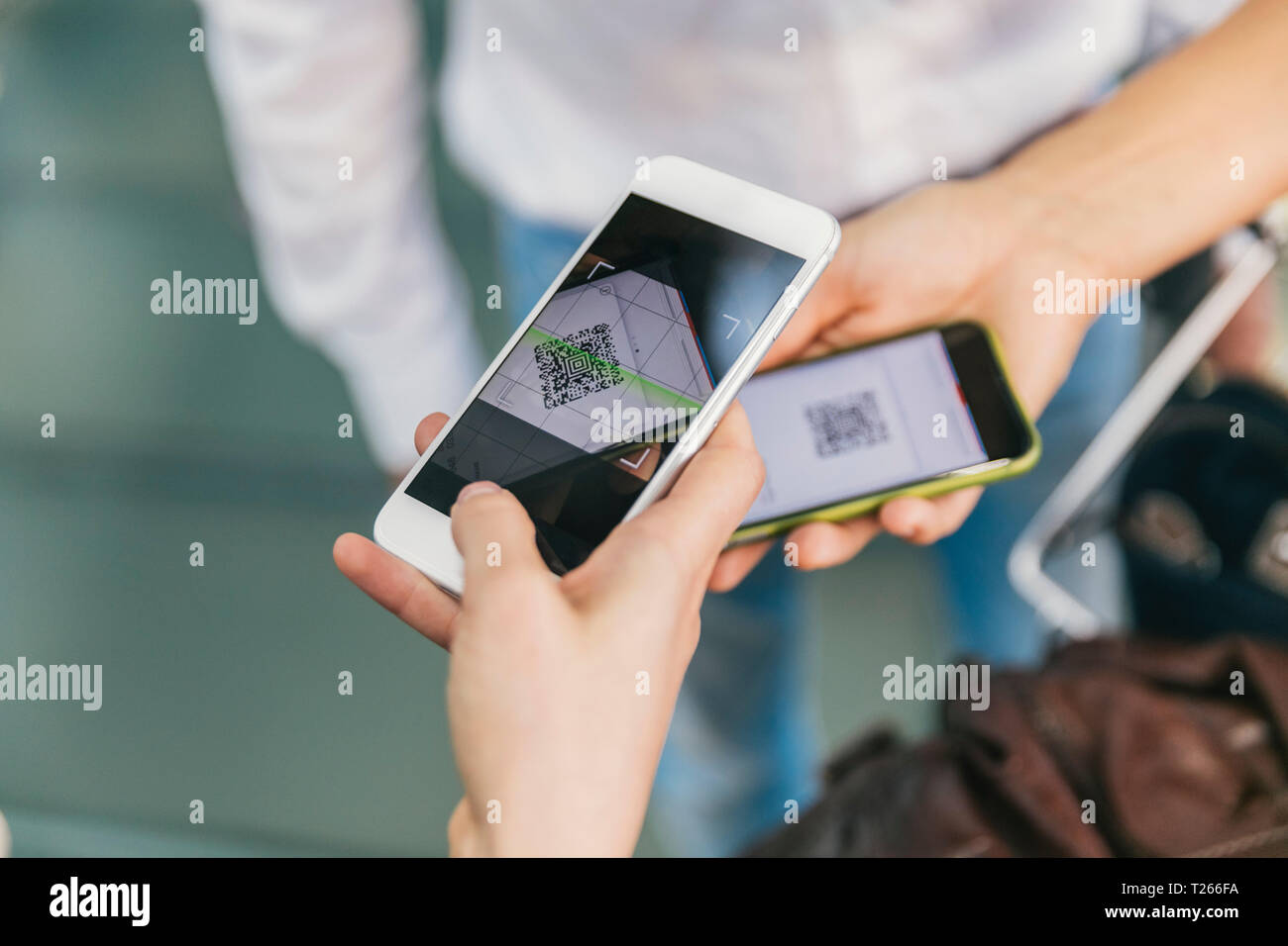 Dipendente della compagnia aerea di scansione dei codici QR di passeggeri con lo smartphone in aeroporto Foto Stock