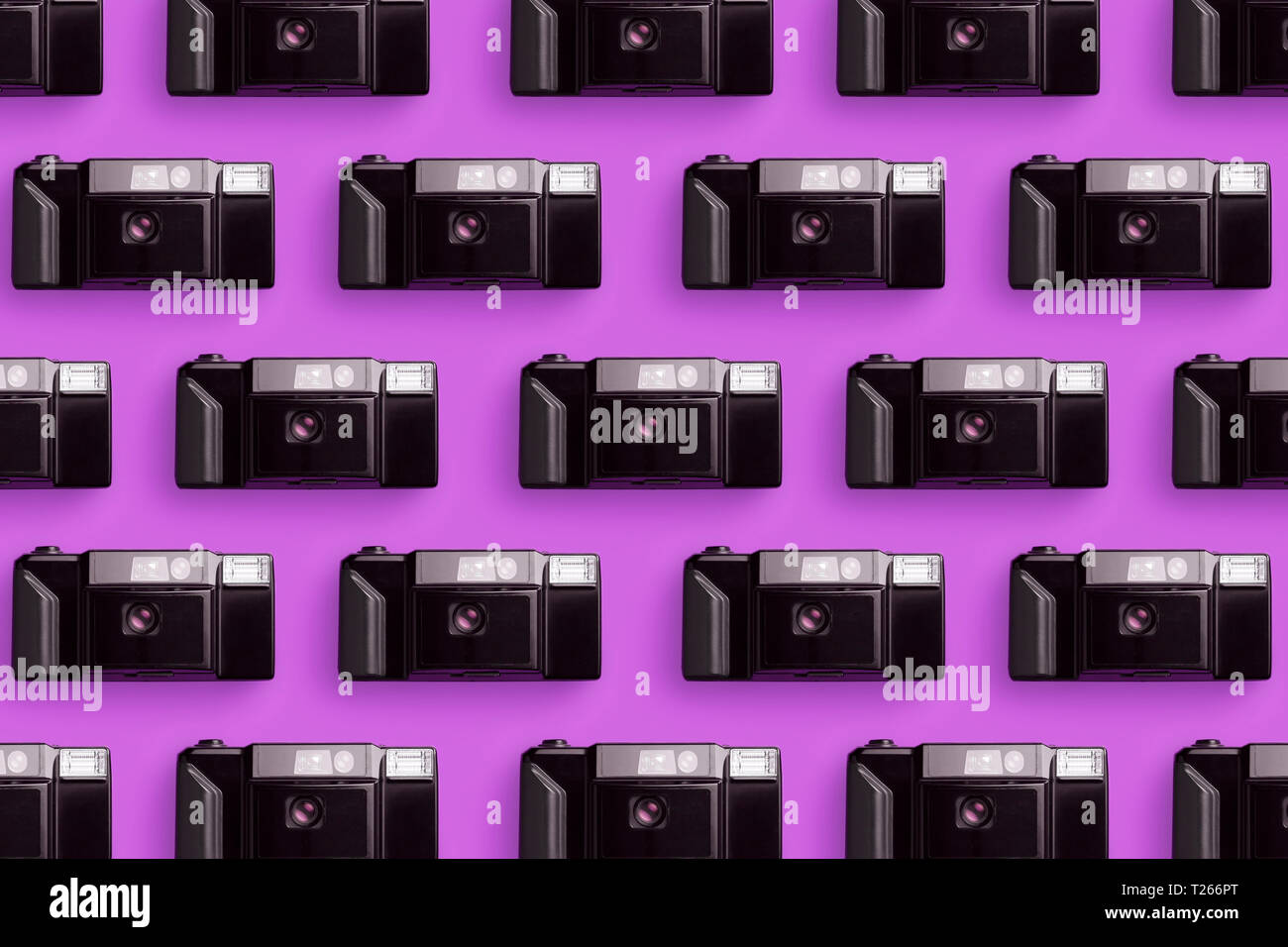 Plastica fotocamere foto organizzate in una fila su sfondo rosa Foto Stock