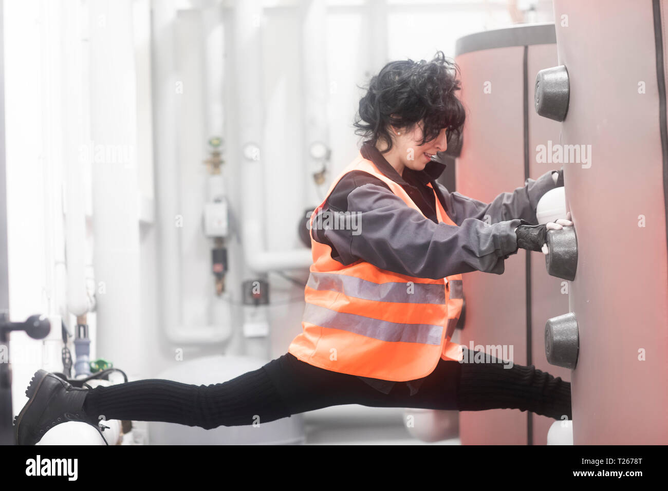 Il tecnico facendo i gruppi nella sala caldaie Foto Stock
