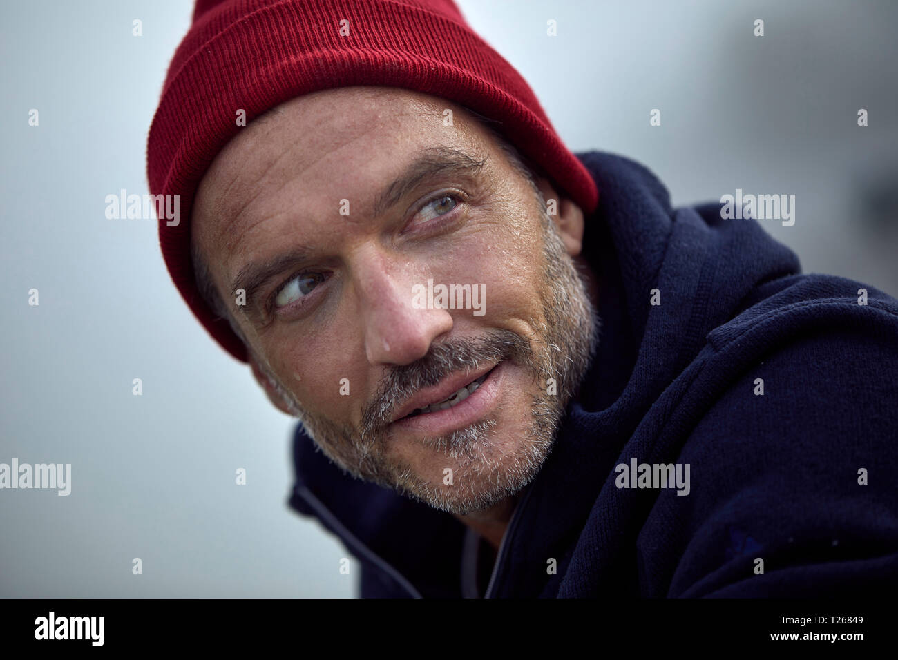 Ritratto di barbuto uomo maturo che indossa cappuccio rosso all'aperto Foto Stock