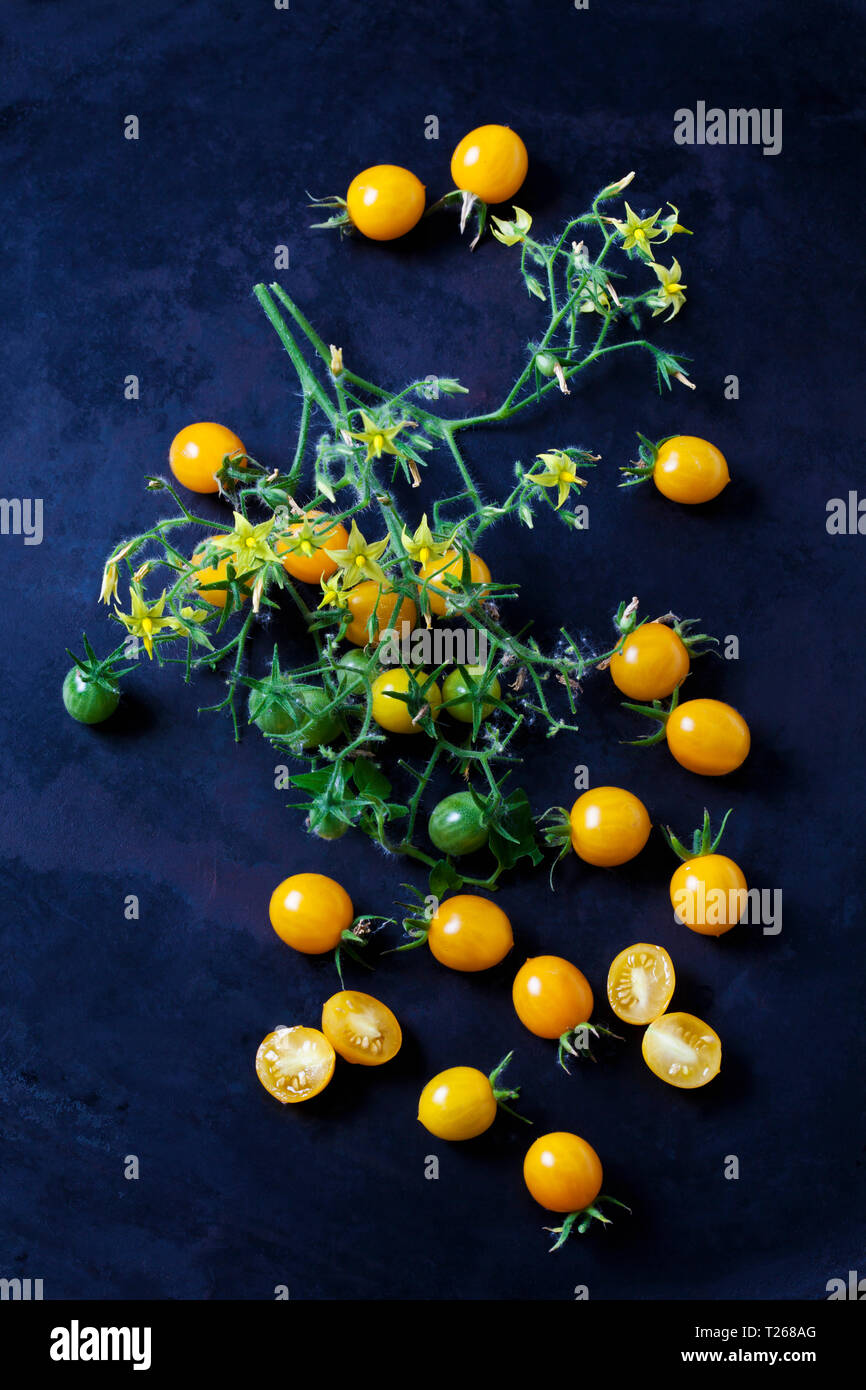 Whiole e pomodori a fette 'Blondköpfchen' sul terreno scuro Foto Stock