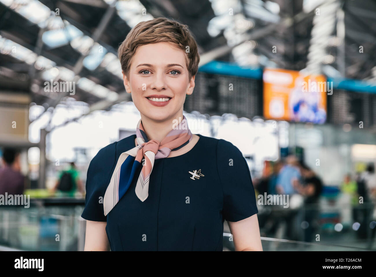 Ritratto di sorridente dipendente della compagnia aerea in aeroporto Foto Stock