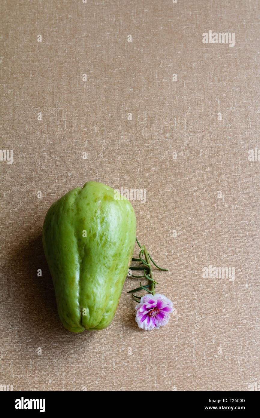 Chayote frutta e piccolo fiore con backgroud testurizzato. Foto Stock