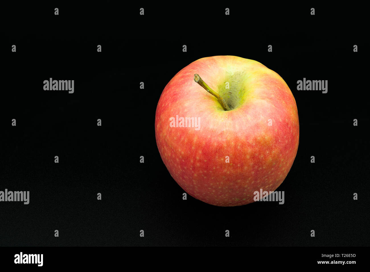 Fresh succosa mela rossa isolato vicino-uo su uno sfondo nero. Foto Stock