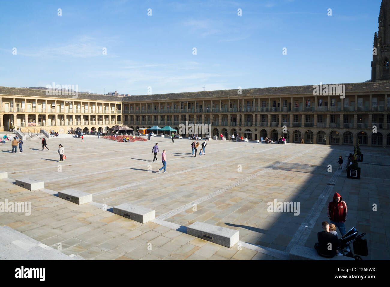 La piazza centrale e area del quadrangolo del pezzo Hall. Sunny / sun & blue sky. Halifax, West Yorkshire, Regno Unito. La parete nord è illuminata dalla luce del sole; la parete est è in ombra. (106) Foto Stock