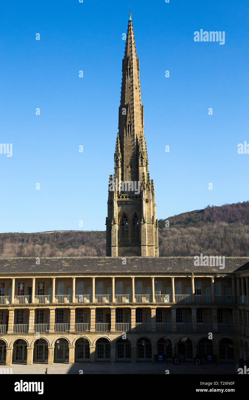 La Piece Hall con piazza Chiesa Cappella guglia dietro in background. Sunny / sun & blue sky. Halifax, West Yorkshire, Regno Unito. (106) Foto Stock