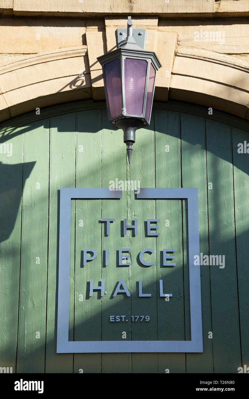 Gate nella parete ovest, ingresso da Westgate, nella Piece Hall. Piece Hall il logo è visualizzato. Sunny / sun & blue sky. Halifax, West Yorkshire, Regno Unito Foto Stock