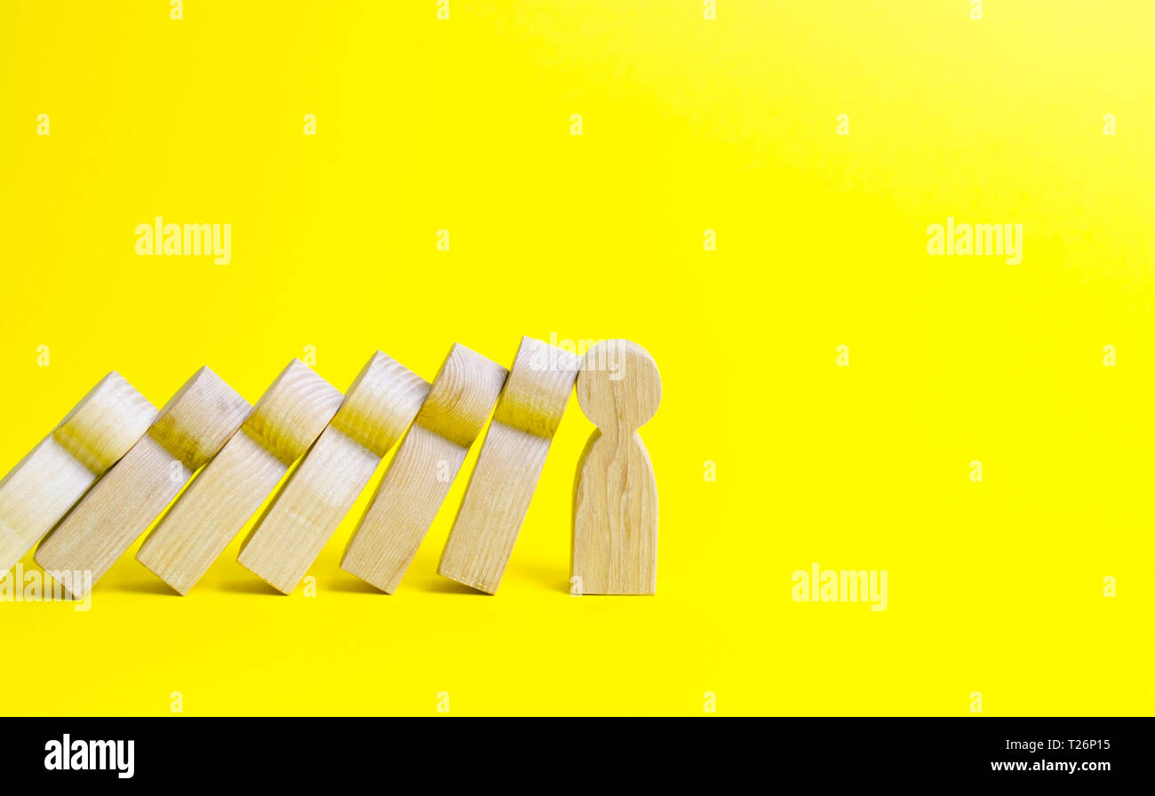 La figura di una persona si arresta la caduta di una serie di figure come effetto domino. Colaps domino. Leader forte e supporto affidabile e leale. Il treno di business Foto Stock