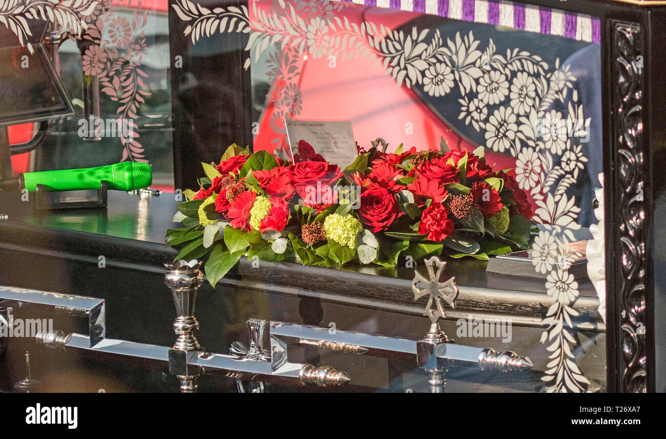 Essex, Regno Unito. Il 30 marzo 2019. Il cavallo e corteo funebre del tardo Prodigy cantante Keith Flint fa il suo modo attraverso le strade affollate di Bocking, Braintree, Essex oggi sulla rotta verso St Marys Chiesa. Un microfono di verde e nota posto su una corona di fiori sulla parte superiore della bara legge " ad un figlio e fratello che è tanto amata e tristemente mancato. Un sacco di amore mamma, papà…." Credito: Phil Rees/Alamy Live News Foto Stock