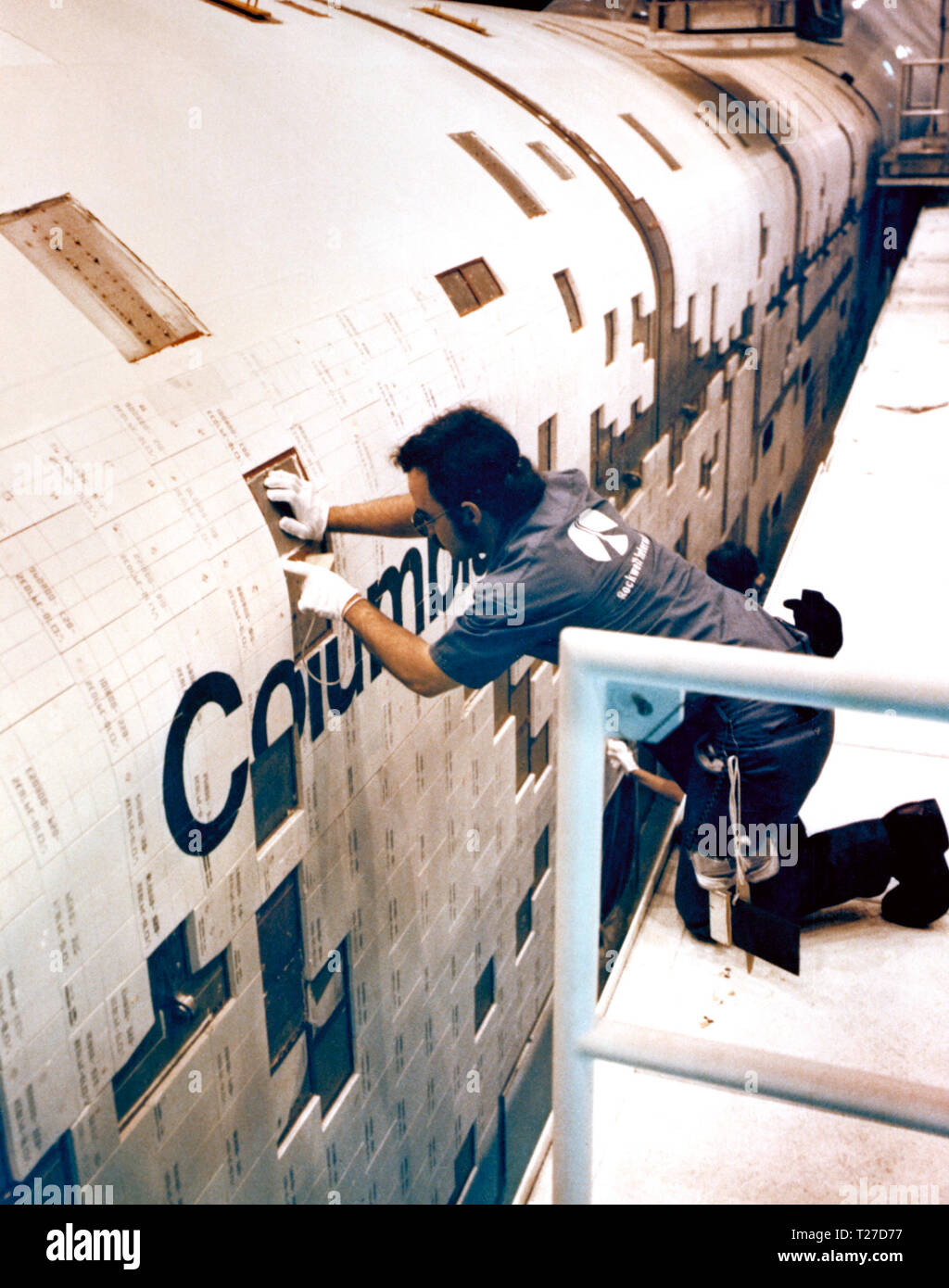 Rockwell International tecnici montare le piastrelle di ceramica sulla parte esterna dello space shuttle Columbia ca. 1980 Foto Stock