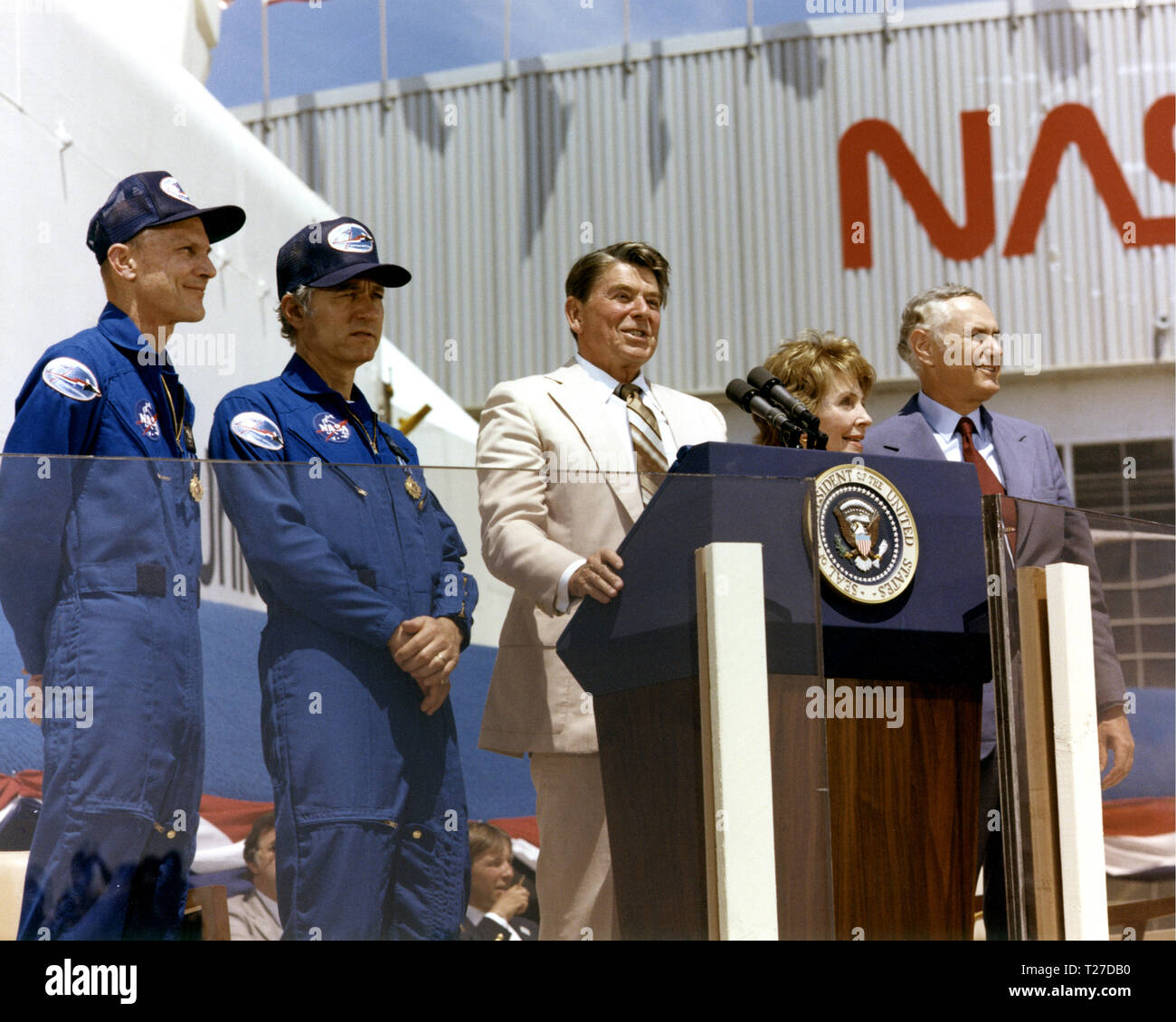 Il Presidente Ronald Reagan parla a una folla di oltre 45.000 persone alla NASA Dryden Flight Research Center dopo lo sbarco di STS-4 il 4 luglio 1982. A destra del Presidente sono la Signora Reagan e amministratore della NASA James M. Beggs. A sinistra sono STS-4 Columbia astronauti Thomas K. Mattingly e Henry W. Hartsfield, Jr. prototipo Space Shuttle Enterprise è in background. Foto Stock