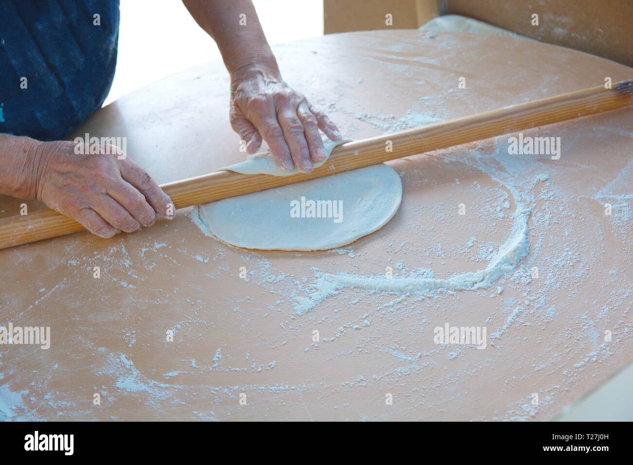 Donna che rende 'bazlama' e 'yufka'. impasto crudo si apre con perno di rotolamento Foto Stock
