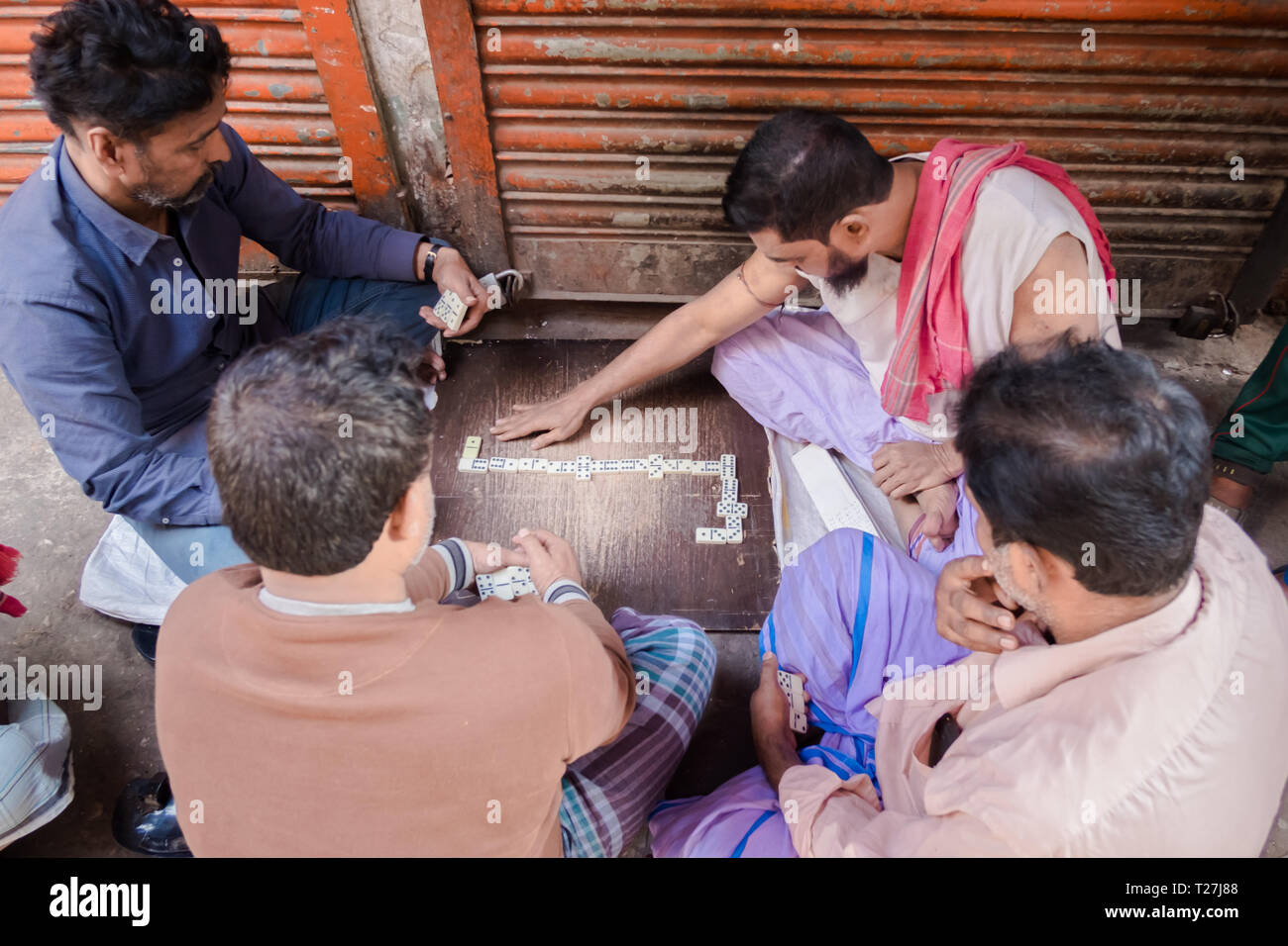 4 Gli uomini seduti sul marciapiede e la riproduzione di domino a Ginevra  Camp, filamento enclave pakistani a Dhaka, nel Bangladesh Foto stock - Alamy
